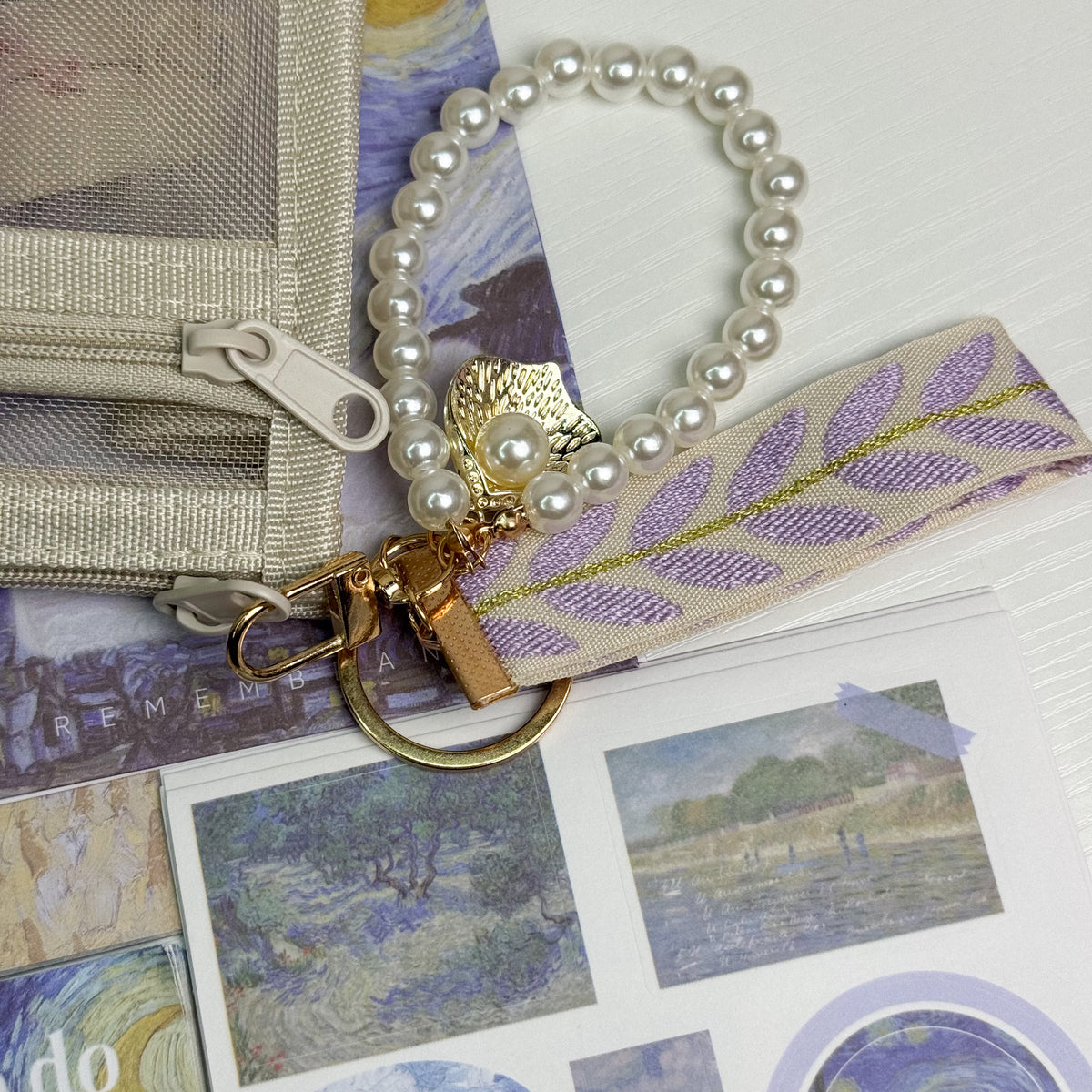 Pearl keychain with golden shell charm and woven floral tassel